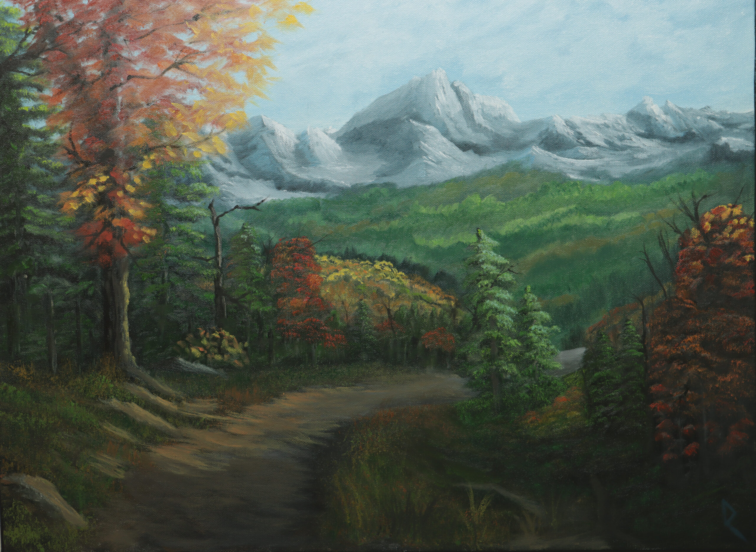 Oil painting of a mountain valley in autumn on 18"x24" canvas. A mountain range in the distance overlooks a dense, forested valley. A path of trees, rocks and grass leads toward the valley. Sunlight creates dynamic highlights amongst the mountains, forests and leaves.